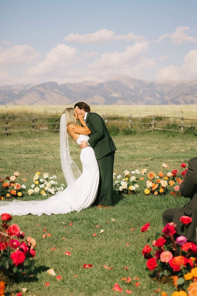 Wedding couple kissing with Montana mountains in the background